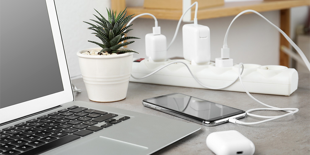 Image of various electronics devices being charged while connected to a power bar